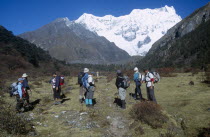 BHUTAN, Snowman Trek, Group of travellers hiking on a trail near Limithang beneath Mount Gangcheta Great Tiger Mountain.