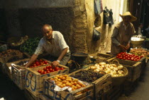 MOROCCO, Fez, Male stallholders behind crates of produce at the fruit market in the souk.