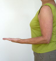 Health, Body, Arms, Woman in profile from side with arm bent at elbow with palm of hand facing upwards and fingers outrstretched.