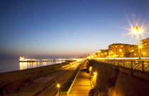 England, East Sussex, Brighton, Kemptown, view over Madeira Drive from Marine Parade with the pier illuminated at sunset. Skies clear due to no fly zone over uk because of Icelandic volcanic dust fear...