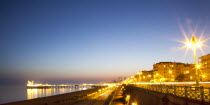 England, East Sussex, Brighton, Kemptown, view over Madeira Drive from Marine Parade with the pier illuminated at sunset. Skies clear due to no fly zone over uk because of Icelandic volcanic dust fear...