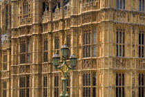 England, London, Westminster,  Houses of Parliament, detail of a section of the building with green ornate lamp post in front.
