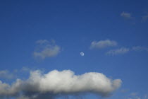 Cloudy blue sky with moon  and distant jet airplane visible, England, West Sussex, Shoreham-by-Sea.