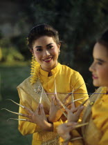 Thailand, women in traditional dress with nail extensions.
