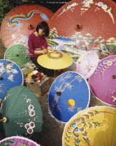 Thailand, Local woman painting traditional umbrellas.