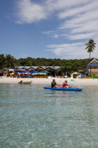 Malaysia, Pulau Perhentian Kecil, Terrengganu coast with two people canoeing close to beach.