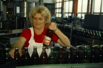 Czech Republic, Bohemia, Ceska Budejovice, woman working in Budweiser brewery bottling factory.