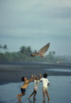 Indonesia, Bali, Children flying kite on the beach.