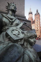 Poland, Krakow, Detail of female figure & child on monument to the polish romantic poet Adam Mickiewicz by Teodor Rygier in 1898 in the Rynek Glowny market square with Mariacki Basilica or Church of S...