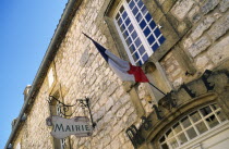 France, Aquitaine, Villefranche-du-Perigord, Mairie Town Hall stone building with French Tricolour flag on flagpole attached to building wall.