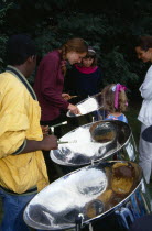 England, West Sussex, Chichester, Multicultural group of young people playing steel drums or pans.