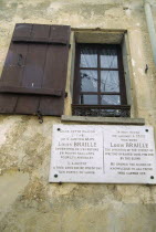 France, Ile de France, Coupvray, Marble commemorative plaque under a shuttered window on the wall of the house where Louis Braille lived in the commune.