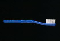 Health, Teeth, Dental Care, Blue toothbrush against a black background.