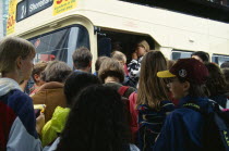 England, East Sussex, Brighton, Young teenage people boarding a crowded bus at a bus stop in the town centre.