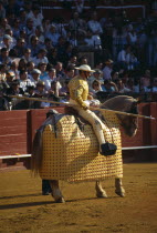 Spain, Andalucia, Seville, Picador with lance riding a padded and blindfolded horse in the bullring at a bullfight in Arenal District.