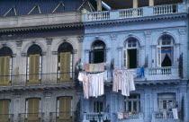 Cuba, Habana, Havana, Colourful colonial buildings along the Malecon with washing hanging from lines across the balconies.