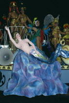 Cuba, Matanzas, Varadero, Carnival float decorated with a papier mache mermaid with people in costume dancing on the float.