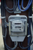 Thailand, Bangkok, Electricity supply meter showing reading and power cables running to it.