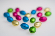 Food, Sweets, Chocolate, Colourful foil wrapped Easter eggs in the shape of a Valentine heart on a white background.