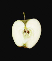 Food, Fruit, Apples, One single ripe green apple cut in half against a black background showing the core and seeds.