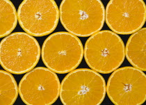 Food, Fruit, Oranges, Overhead view of group of oranges cut in half showing core and segments against a black background.