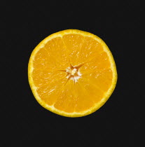 Food, Fruit, Oranges, One single ripe orange cut in half showing core and segments against a black background.
