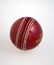 Sport, Ball Games, Cricket, Red hand stitched leather cricket ball on a white background.