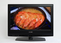 Communications, Media, Television, Sony Bravia Wide Flat Screen TV on a white background showing a cookery programme with large prawns frying in a pan on a gas cooker ring.