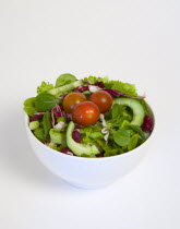 Food, Vegetables, Salad, White bowl of green leaf salad with tomatoes and cucumber on a white background.