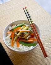 Food, Cooked, Vegetables, Stir fried vegetables and plain boiled rice in a bowl with chopsticks sitting on a bamboo table mat.