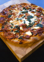 Food, Cooked, Pizza, Italian spinach and ricotta cheese pizza on wooden cutting board.