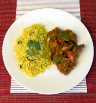 Food, Cooked, Curry, Indian chicken Jalfrezi curry with yellow pilau rice on a white plate.