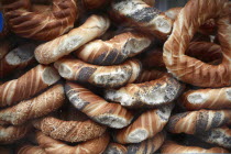 Poland, Krakow, Obwarzaneck, twisted rings of bread strewn with poppy sale for sale from street vendors stall.