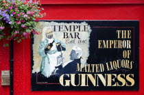 Ireland, County Dublin, Dublin City, Temple Bar pub sign on red wall promoting Guinness.