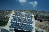 Environment, Alternative Energy, Solar Panel, Modern solar panel perched on traditional tiled rooftop.