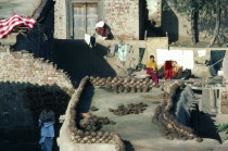 Pakistan, Women with dung laid out to dry on rooftops for use as fuel.