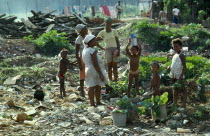 Brazil, Bahia, Salvador, Slum dwelling family foraging on rubbish dump for things to sell.