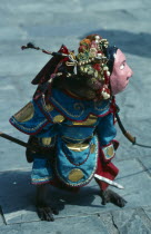 China, Hong Kong, New Territories, Performing monkey dressed in elaborate costume and mask.
