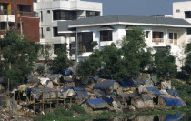 Bangladesh, Dhaka, Slum dwellings with expensive apartments behind.  