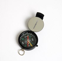 Travel, Navigation, Map Reading, Sighting compass with dial pointing to magnetic north on a white background.