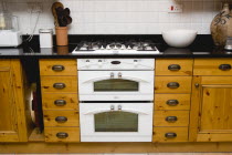 Architecture, Interiors, Kitchen, White domestic gas hob and electric oven household appliance set under worktop in fitted integrated kitchen.