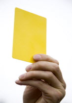 Sport, Ball Games, Referees, Referee showing yellow caution booking card in raised hand.