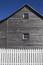 Ireland, County Tyrone, Omagh, Ulster American Folk Park, Western Pennsylvania Log House, detail of wooden gable and whitc picket fence.