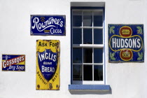 Ireland, County Tyrone, Omagh, Ulster American Folk Park, 19th century advertising on one of the Victorian shopfronts.