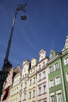 Poland, Wroclaw, pastel coloured building facades & street light in the Rynek old town square.