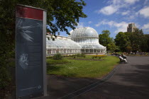 Ireland, Northern, Belfast, Botanic Gardens with people sat on benches outside the Palm House next to Queens University both designe by architect Charles Lanyon.