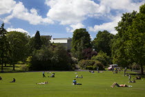 Ireland, North, Belfast, Botanic Gardens with people relaxing in the sun.