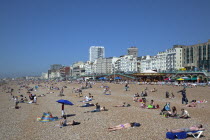 England, East Sussex, Brighton, people sunbathing on the pebble beach.