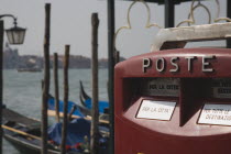 Italy, Veneto, Venice, Post box with gondolas moored on the Grand Canal behind.