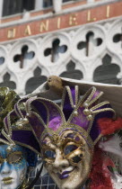 Italy, Veneto, Venice. Carnival masks in front of partly seen facade of Hotel Danieli.